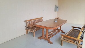 A room with a wooden table and two wooden benches. - OYO Life 93590 Penginapan Palapa 10 Syariah (Bandar Lampung)