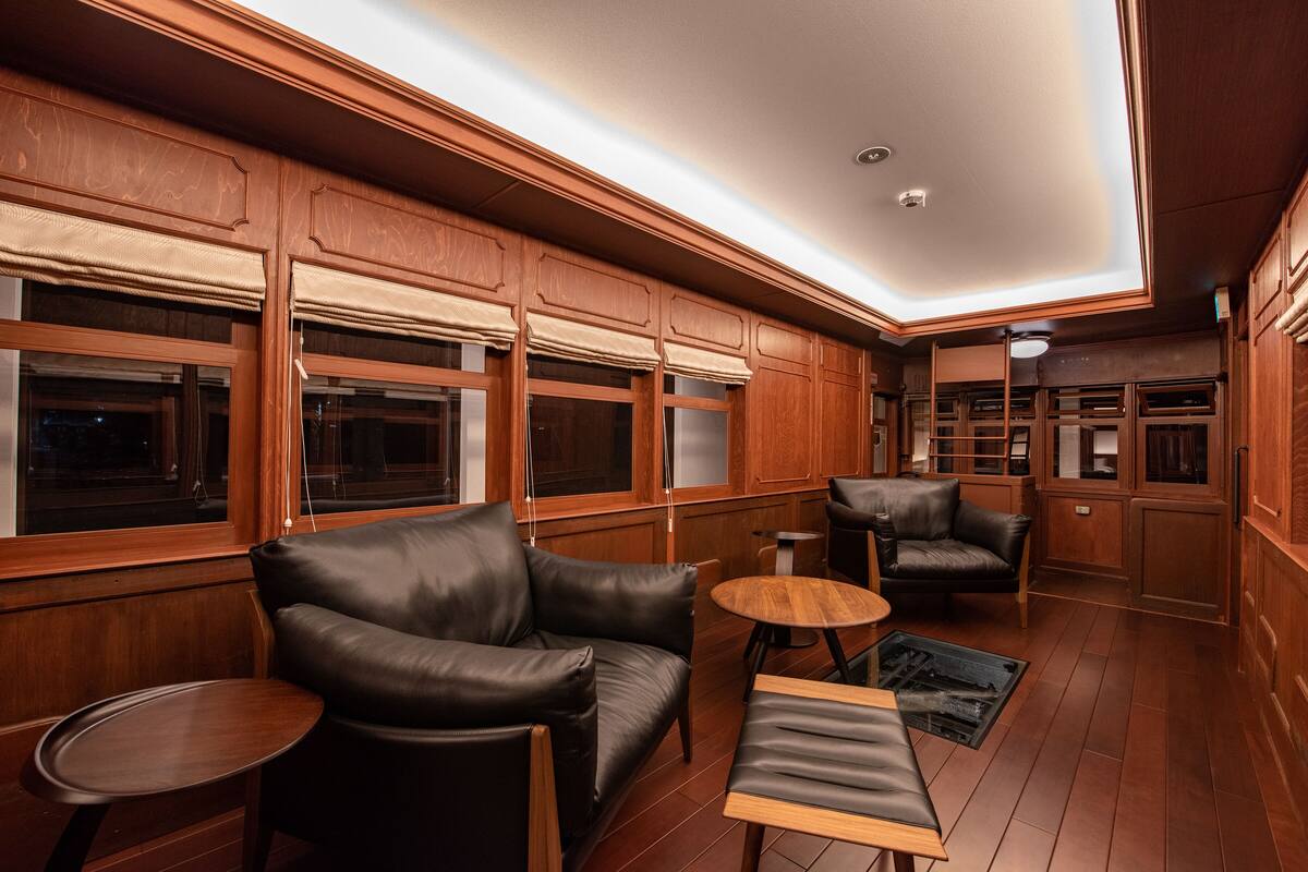 A room with wooden paneling, leather seating, and built-in cabinetry.