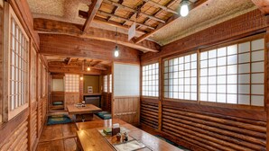 Ein traditionelles japanisches Gasthaus mit Tatami-Bodenbelag, Holzwänden und verschiebbaren Türen.