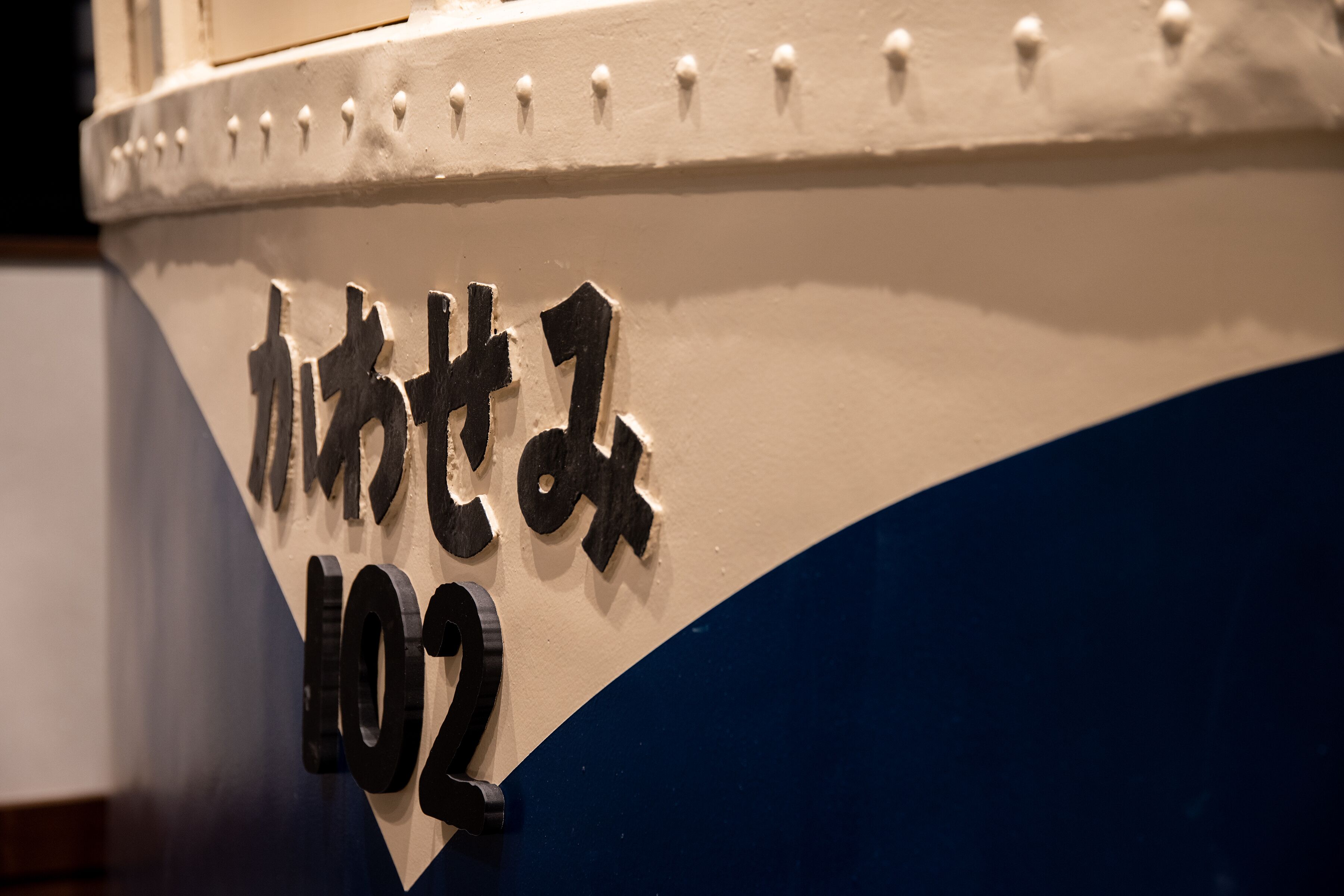 A boat with the number 102 and Japanese characters on its side.