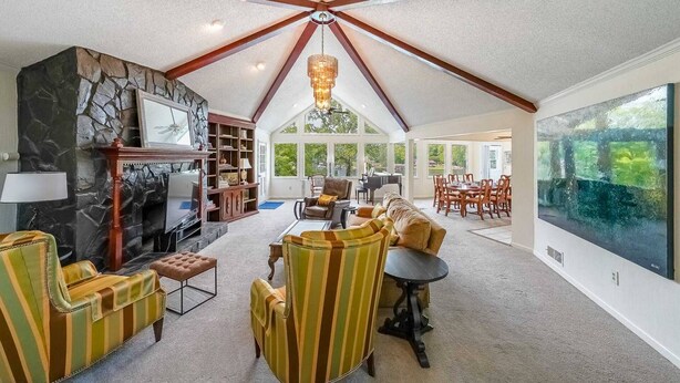 A spacious living room with a fireplace, a large window, and a dining area with chairs and a table. - Great for Traveling Work Teams /20-30 minutes to downtown Atlanta/Sleeps 12/Private Pool (Jonesboro)