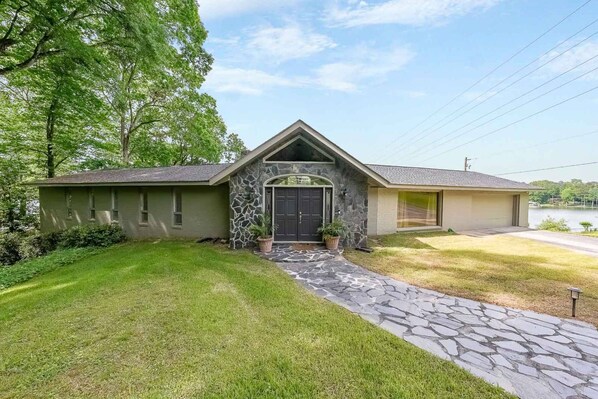 A two-story house with a stone facade, a front porch, and a well-maintained lawn. - Great for Traveling Work Teams /20-30 minutes to downtown Atlanta/Sleeps 12/Private Pool (Jonesboro)
