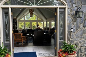 A spacious interior with a high ceiling, a chandelier, and a stone wall. - Great for Traveling Work Teams /20-30 minutes to downtown Atlanta/Sleeps 12/Private Pool (Jonesboro)