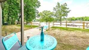 A patio with a table and chairs, overlooking a lake with boats and a dock. - Great for Traveling Work Teams /20-30 minutes to downtown Atlanta/Sleeps 12/Private Pool (Jonesboro)