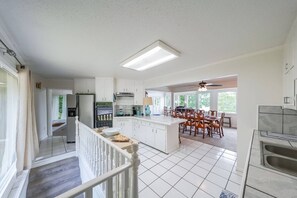 A spacious kitchen with white cabinets, a central island, and a dining area with wooden chairs. - Great for Traveling Work Teams /20-30 minutes to downtown Atlanta/Sleeps 12/Private Pool (Jonesboro)