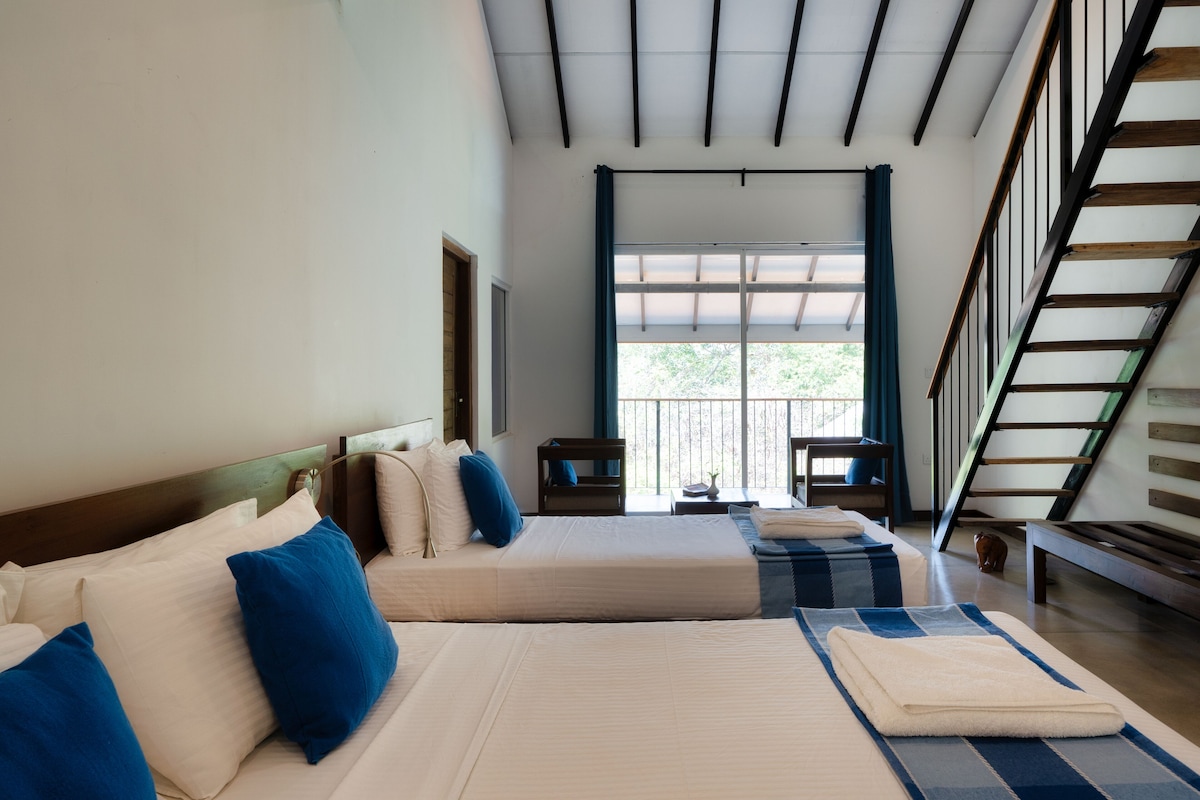 Une chambre d’hôtel avec deux lits, une tête de lit en bois, une fenêtre donnant sur un paysage agréable et un escalier.