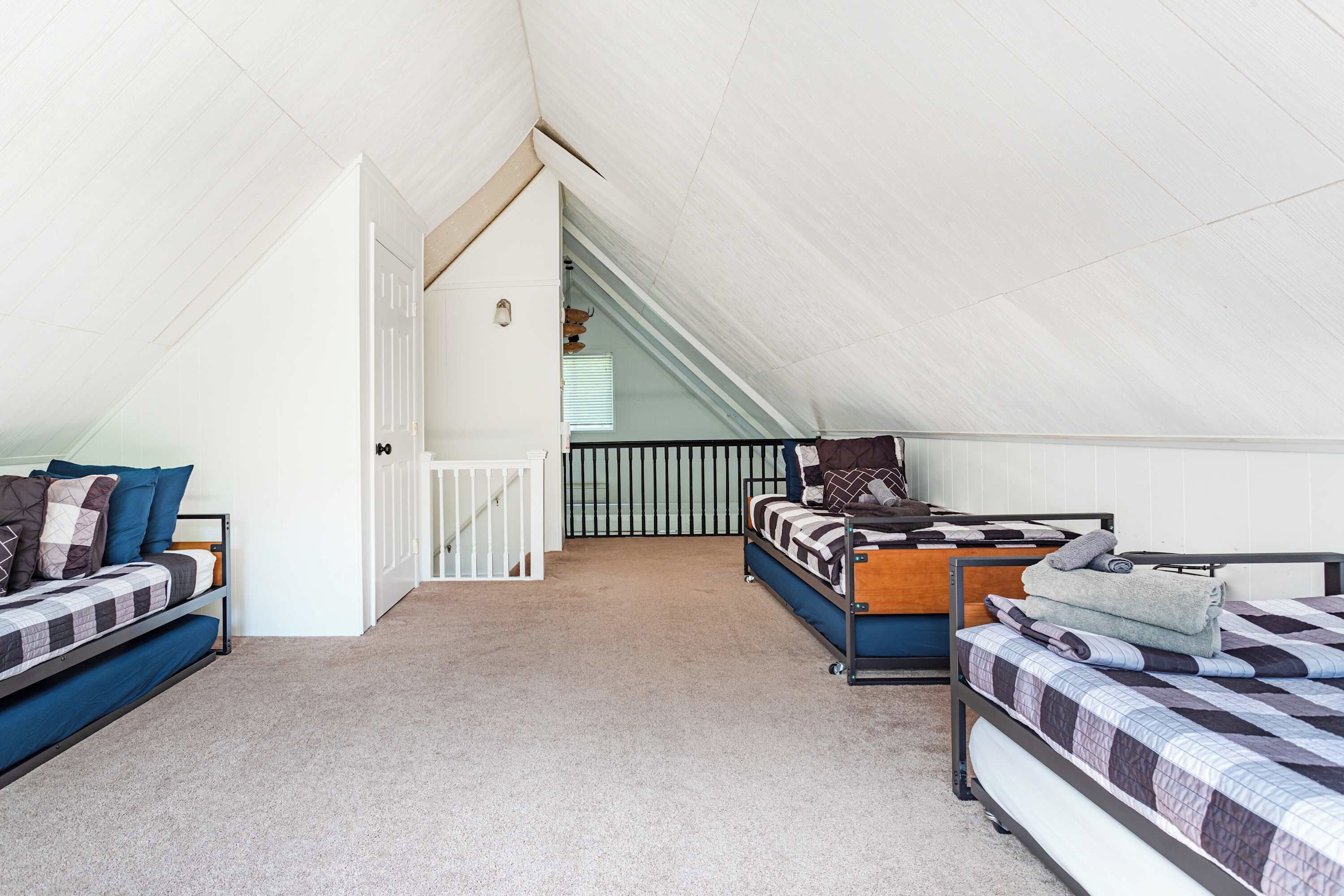 Een kamer in een studentencomplex met stapelbedden, een trap en een wit plafond.