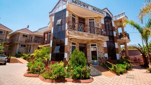 A multi-story hotel with a prominent sign reading "Mount Royal." It features a modern architectural design with large windows and balconies.