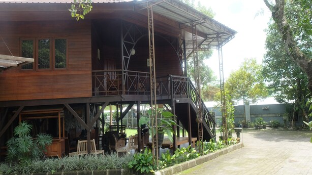 Un bâtiment en bois doté d’un balcon, de sièges en plein air et d’un escalier.