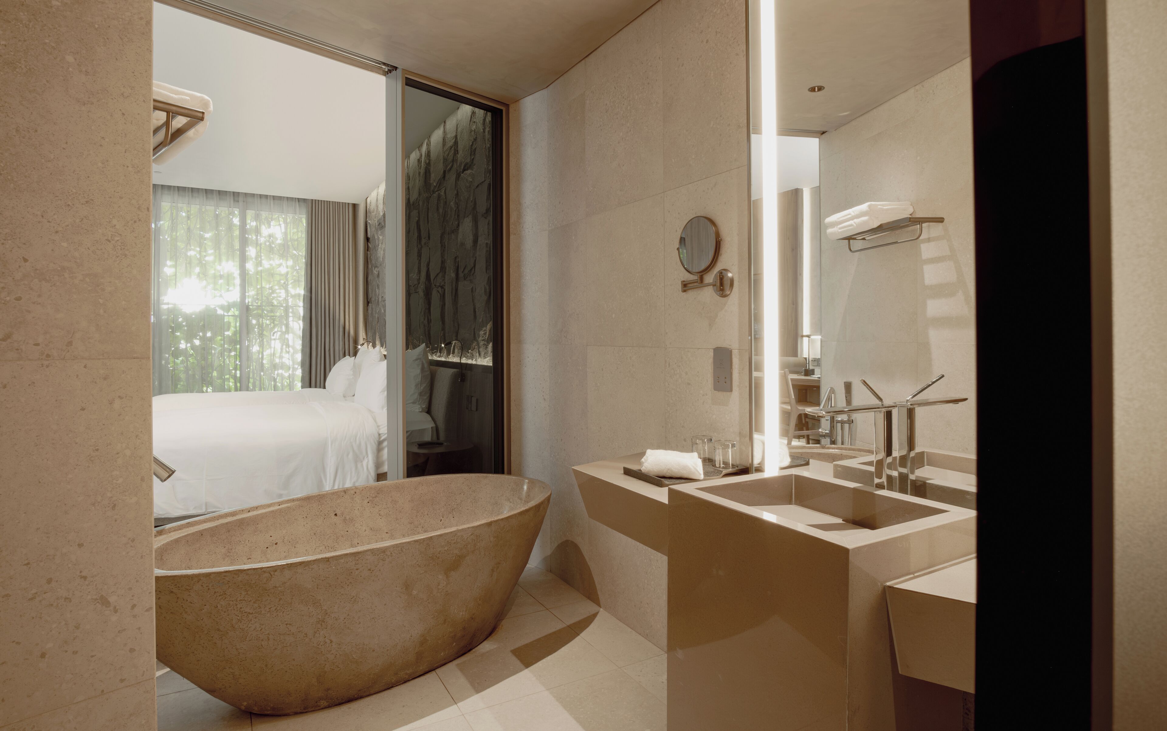 A modern bathroom with a large freestanding bathtub, a separate shower area, and a vanity with a mirror.