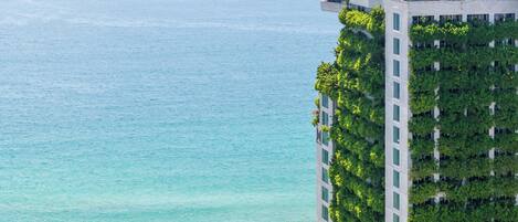 Un hotel moderno de gran altura con piscina en la azotea y exuberantes jardines verticales.