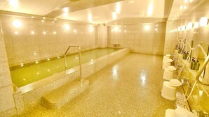 Zona de spa con hidromasaje, paredes alicatadas y una fila de artículos de tocador a la derecha.