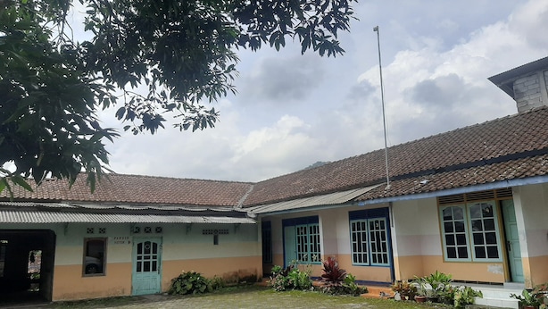 A building with a tiled roof, a blue door, and a sign that reads "PARKING HOSPITAL". - SPOT ON 93596 Pondok Wisata Pesona Asri (Pleret)