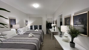 Ein Hotelzimmer mit zwei Betten, einem Schreibtisch und einem Spiegel.