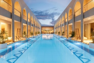 Una piscina al aire libre, sillones reclinables de piscina