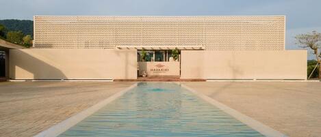 A modern building with a pool in front, a sign reading "NAVAKIRI," and a patterned facade.
