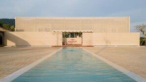 A modern building with a pool in front, a sign reading "NAVAKIRI," and a patterned facade. - Navakiri Boutique Resort Satun (Satun)