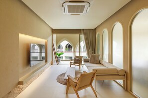 A modern living room with a sofa, chairs, a TV, and a large window. - Navakiri Boutique Resort Satun (Satun)