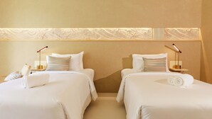 A hotel room with two beds, each with a bedside table, lamp, and a rolled towel. - Navakiri Boutique Resort Satun (Satun)