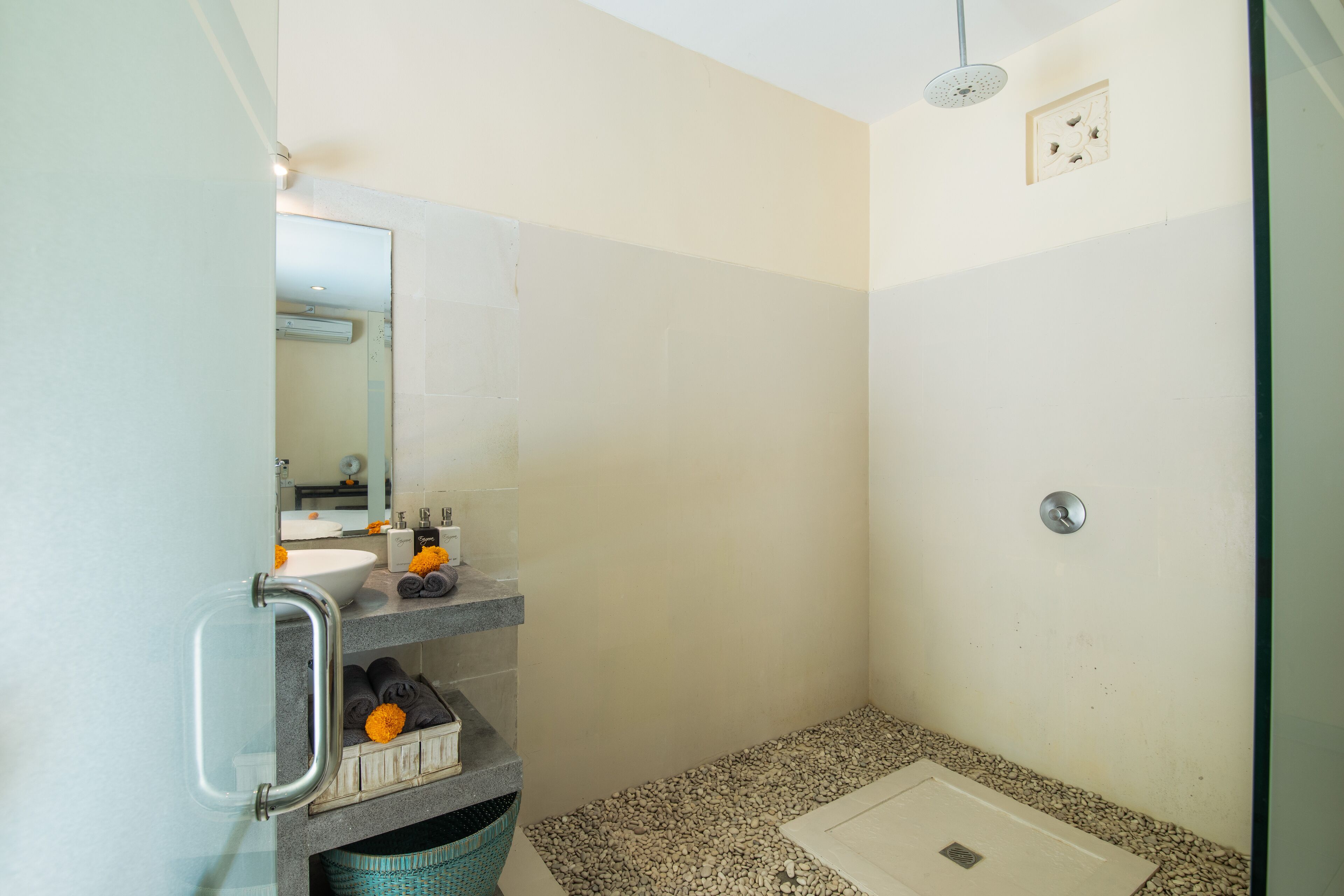 Un baño pequeño con ducha, lavamanos y espejo.