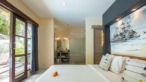 A hotel room with a large bed, a painting on the wall, and a view of the outdoors. - Enigma Bali Villas (Canggu)