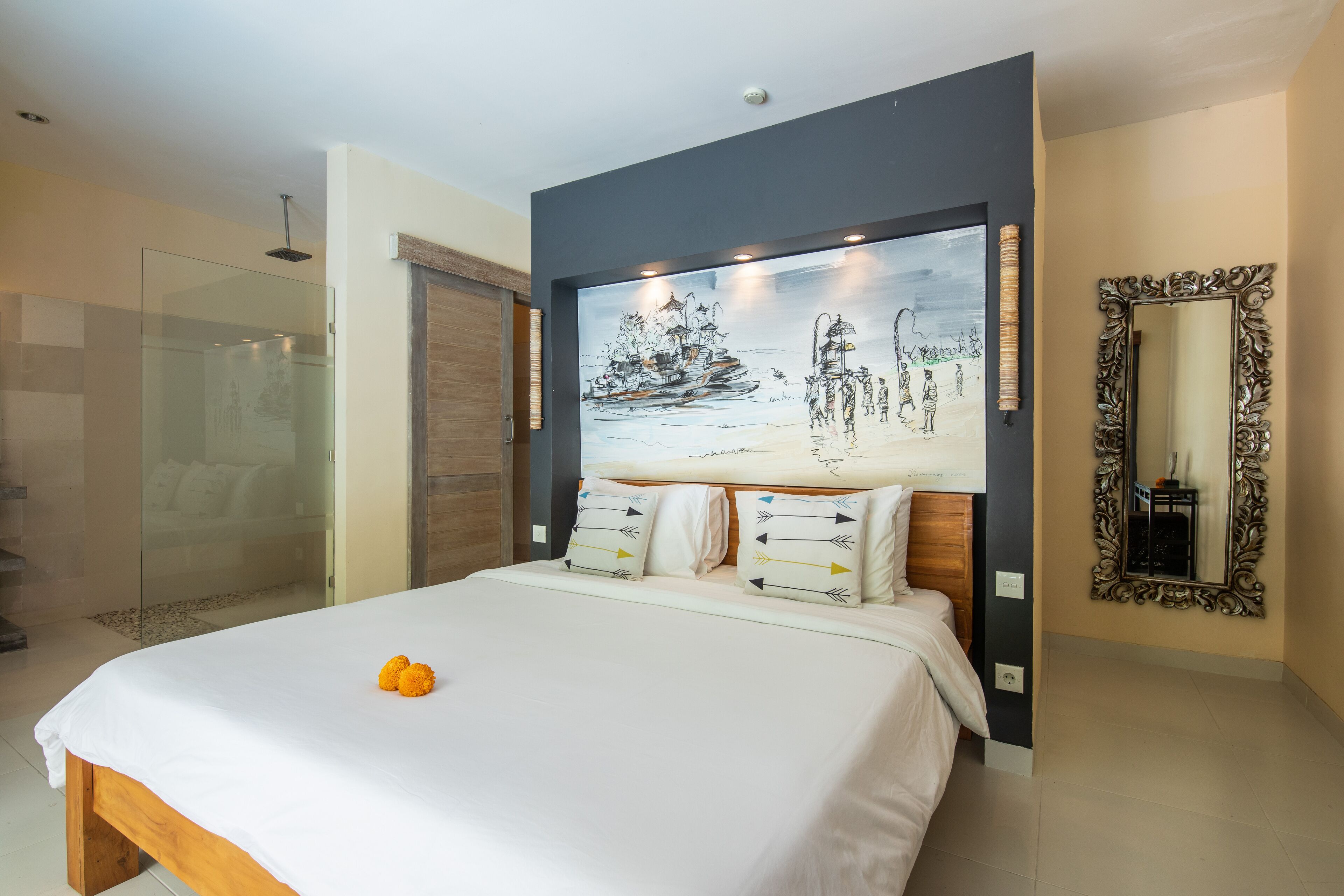 A modern bedroom with a large bed, a glass shower enclosure, a painting on the wall, and a mirror.