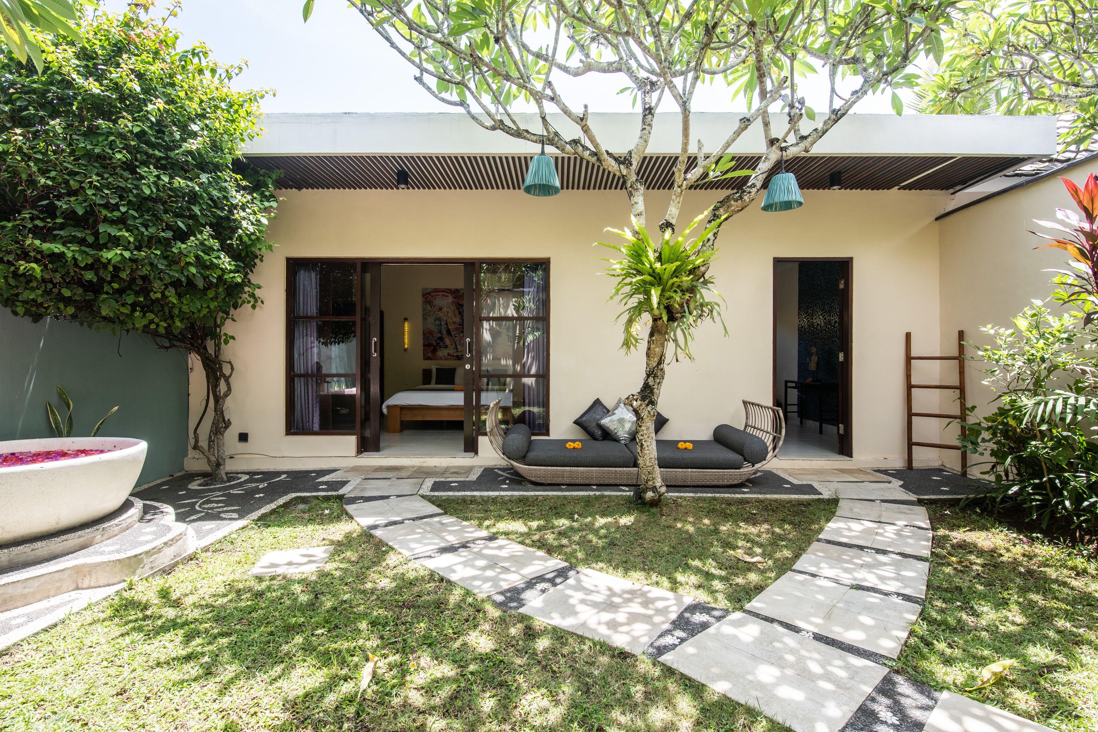 Uma casa moderna com jardim, um conjunto de sofás e uma área de jantar.