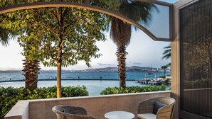 A balcony with wicker furniture, a view of the sea, and a cityscape in the background. - Princes’ Palace Resort - Member of The Leading Hotels of the World (Adalar)