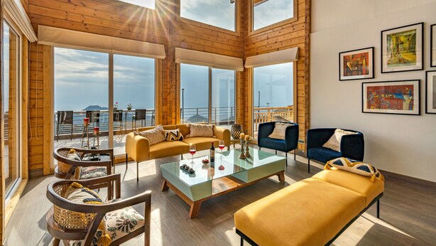 A spacious room with large windows, a glass coffee table, and modern furniture. - Soul Stories - Luxury Villas and Resort, Mussorrie (Dhanaulti)
