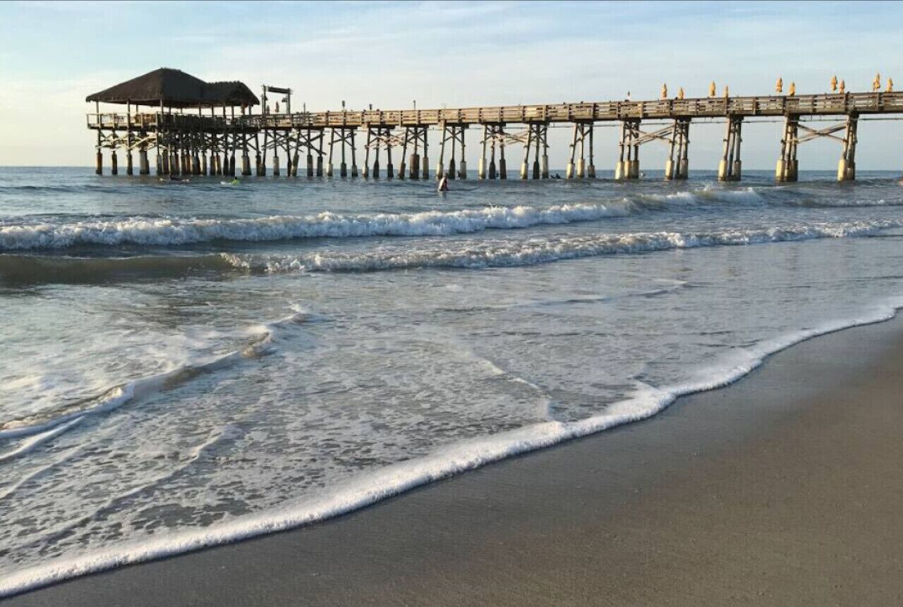 A pier extending into the ocean with a covered area at the end.