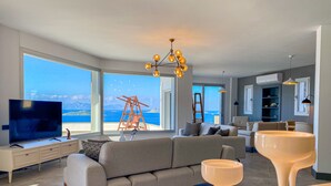 A modern living room with a large TV, comfortable seating, and a view of the sea. - Villa Valentino 1 (Bodrum)