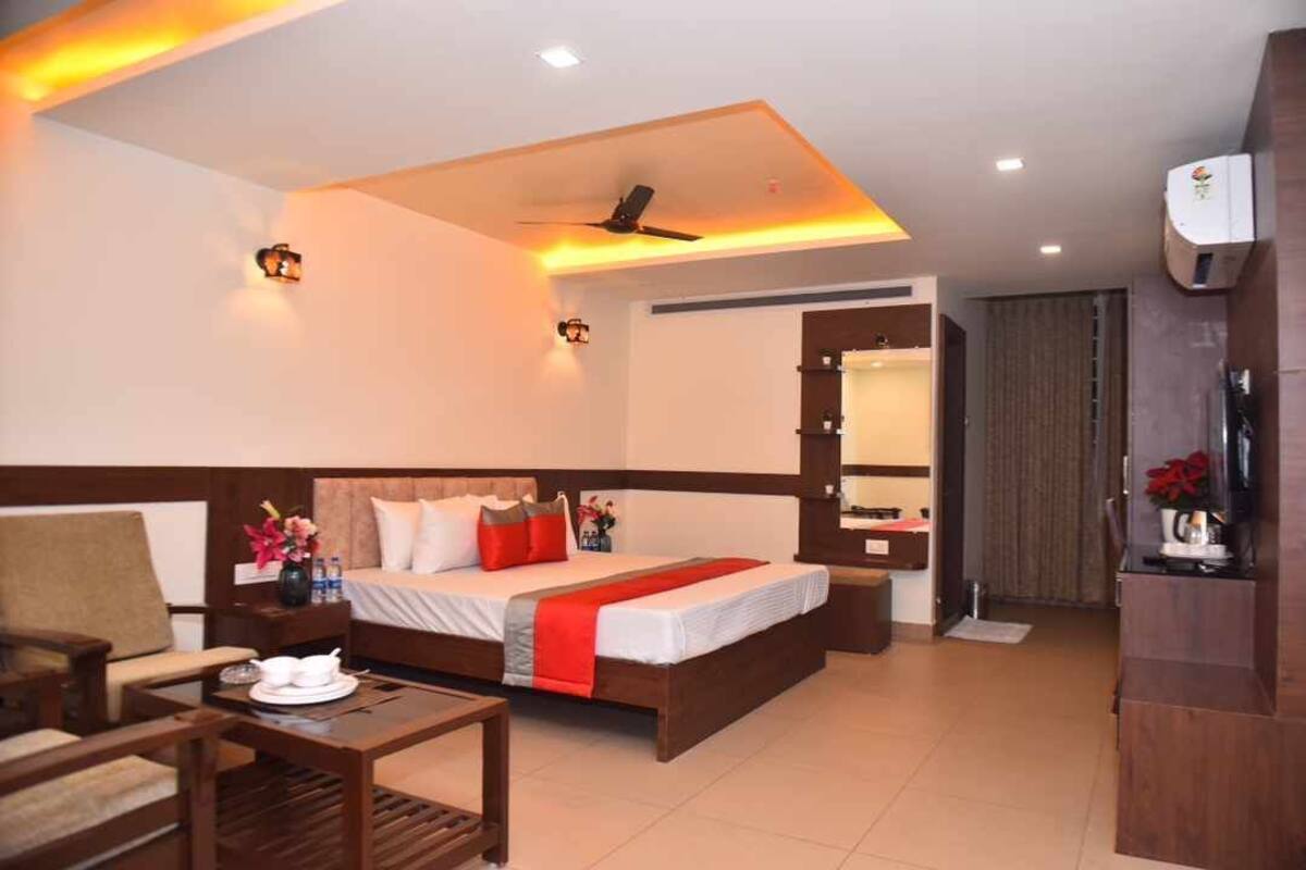 Ein Hotelzimmer mit Bett, Schreibtisch, Stuhl, Nachttisch und Spiegel.