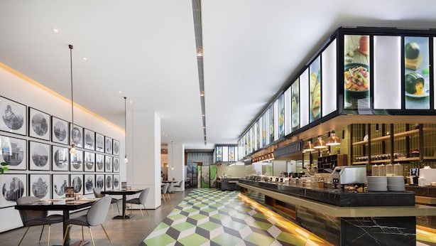 A modern restaurant with a checkered floor, a long counter with a coffee machine, and framed pictures on the walls. - Leeden Hotel Hangzhou (Hangzhou)