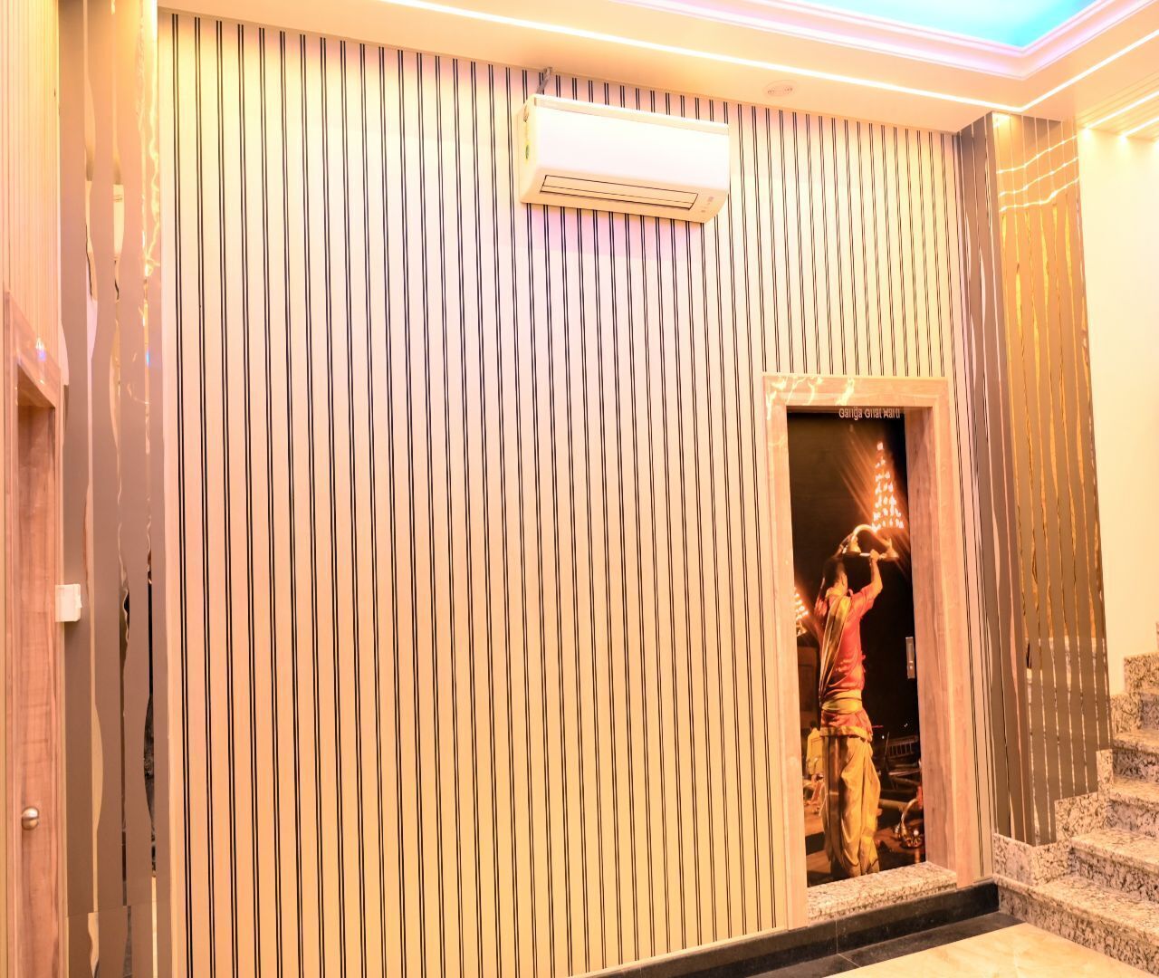 Una habitación de hotel con una pared a rayas, una puerta y una escalera.