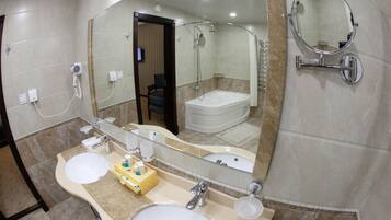 A bathroom with two sinks, a large mirror, and a shower.