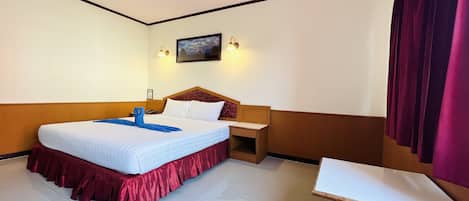 A hotel room with a bed, a desk, and a nightstand.
