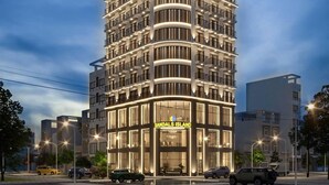 A tall, modern hotel with a curved facade and multiple balconies.