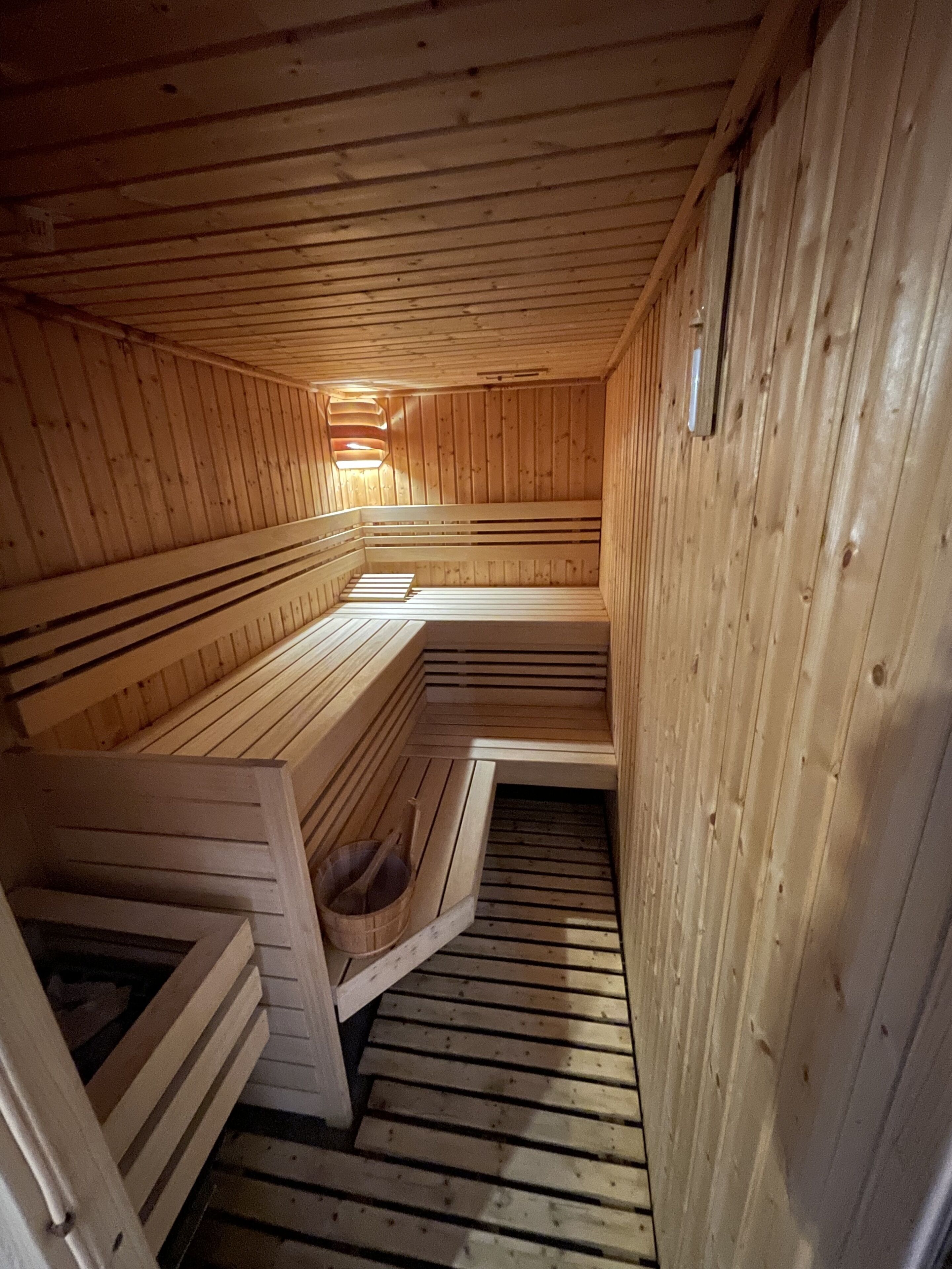 Eine Sauna mit hölzernen Bänken, die in einer halbkreisförmigen Anordnung angeordnet sind.