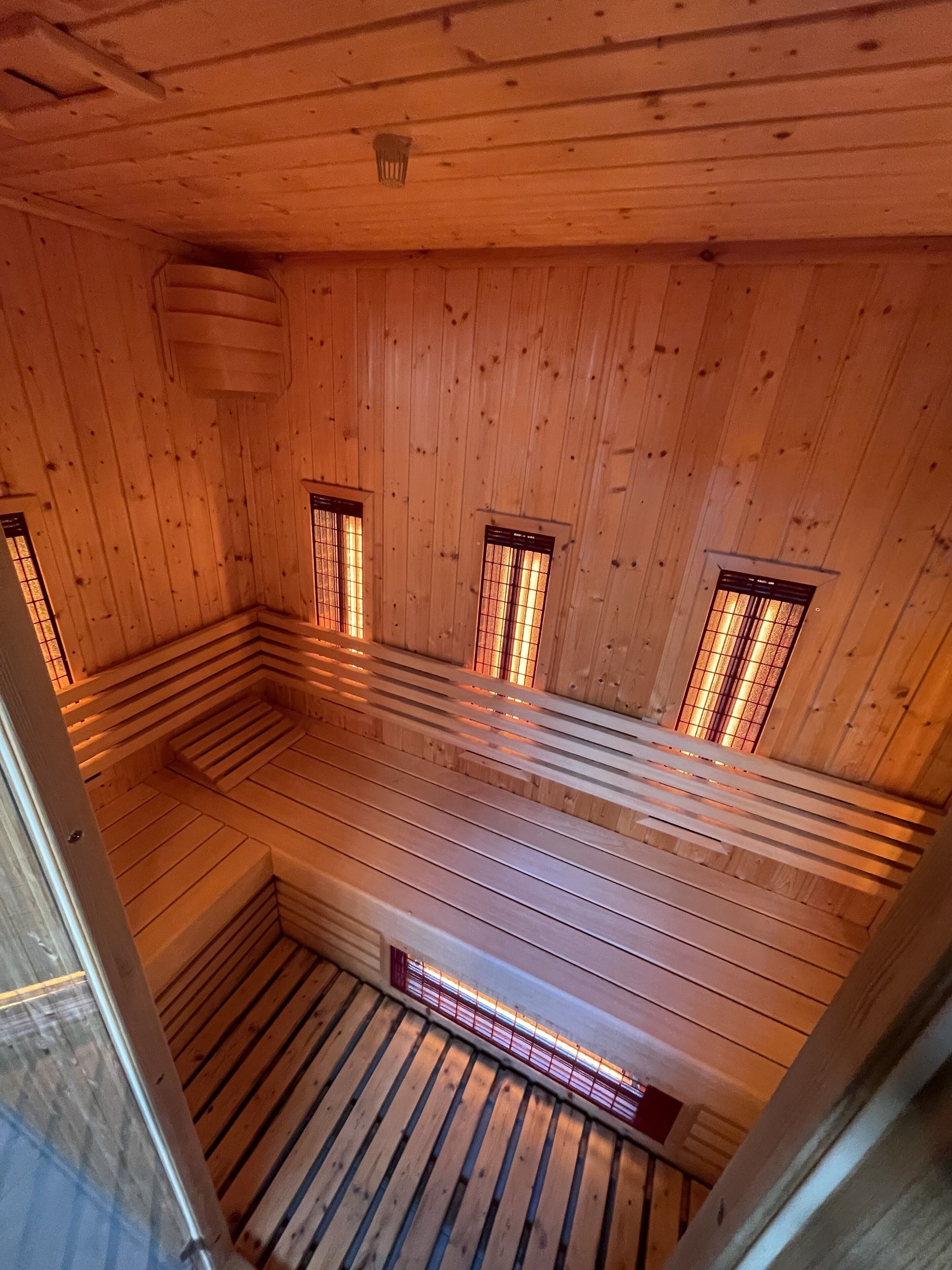Sala de sauna com paredes e bancos de madeira.