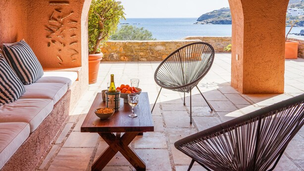 A terrace with a sofa, a table with fruits and a bottle, and two chairs, overlooking the sea. - Exquisite beachfront mansion, 5 bedrooms-Syros (Syros, Kyklades)