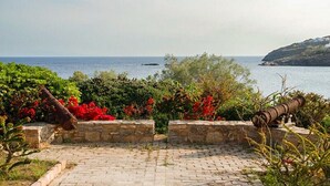 A paved pathway leading to a scenic overlook with a view of the sea and a hill in the distance. - Exquisite beachfront mansion, 5 bedrooms-Syros (Syros, Kyklades)