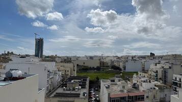 Un paisaje urbano con varios edificios, una grúa de construcción y un estacionamiento.
