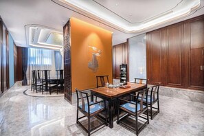 A hotel dining area with a marble floor, a central table with chairs, and a decorative wall. - Shandong Hanlin Hotel (Shandong Normal University Qianfoshan Branch) (Jinan)