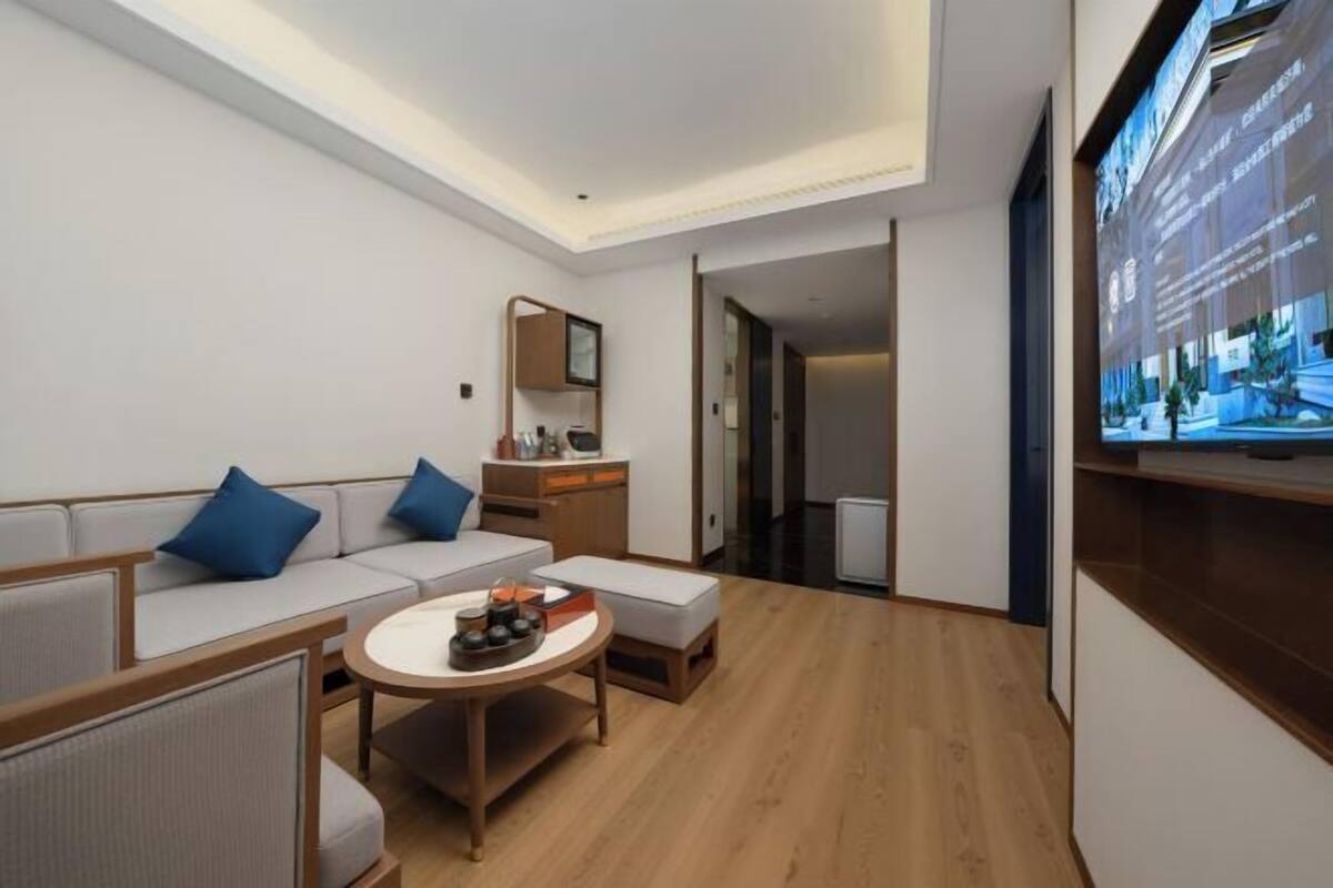 A modern hotel room with a sofa, a small round table, and a cabinet.