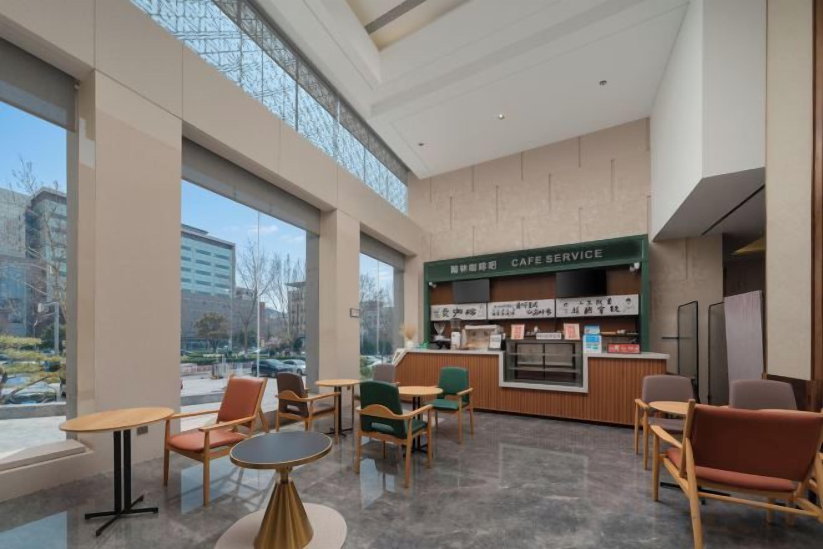 A modern cafe with a counter, seating area, and large windows.