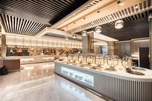 A modern kitchen with a central island, pendant lighting, and a polished floor. - Shandong Hanlin Hotel (Shandong Normal University Qianfoshan Branch) (Jinan)
