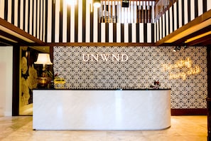 Una reception con carta da parati decorata e un moderno lampadario.