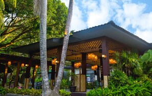 A covered outdoor area with a wooden structure, hanging lights, and lush greenery. - UNWND Boutique Hotel Dumaguete (Sibulan)