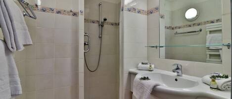 A bathroom with a shower, sink, and mirror.