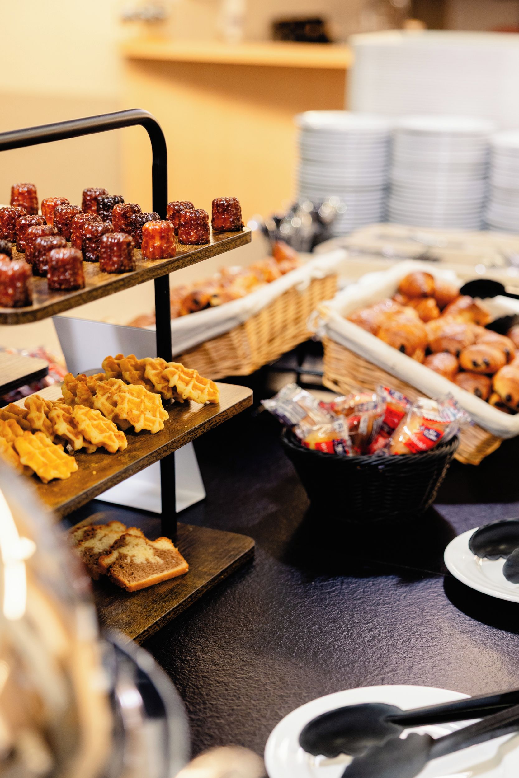 Un bufé con diversas opciones de comida, incluyendo gofres, pasteles y una selección de postres.